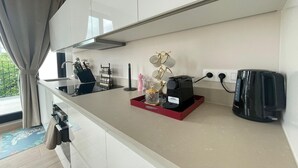 Eine moderne Küche mit Kaffeemaschine, Wasserkocher und Tablett mit einem dekorativen Gegenstand.