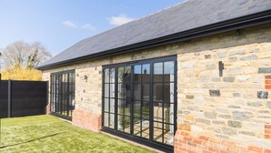 A stone building with large windows and a black roof. - The Annexe of Richmond Barn - Gateway to Cotswolds (Swindon)