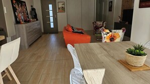 Ein modernes Wohnzimmer mit einem Holzespeisetisch, einem Sofa und einem Sessel.