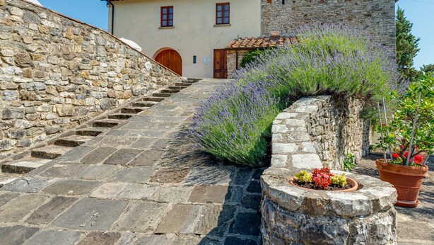 A stone staircase leading to a building with a stone facade and a wooden door. - Spacious Panoramic Apartment with Pool (Pontassieve)