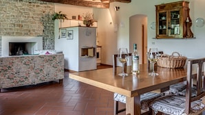 Una cucina rustica con un tavolo di legno, sedie e un camino.