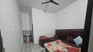 Un dormitorio con cama, ventilador de techo, lavamanos y piso con diseño de mármol.