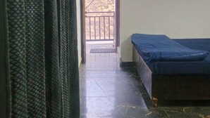 Una habitación con una cama, una puerta que da al exterior y un suelo de mármol.