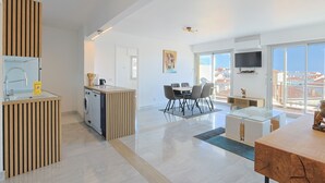 Ein modernes Apartment mit Küche, Essbereich und großem Balkon mit Blick auf die Stadt.