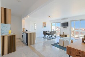 A modern apartment with a kitchen, dining area, and a large balcony with a city view. - 222 - L Azur in Cannes (Cannes)