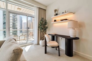 Ein modernes Wohnzimmer mit einer Couch, einem Esstisch mit Lampe, einer Topfpflanze und Blick auf hohe Gebäude.