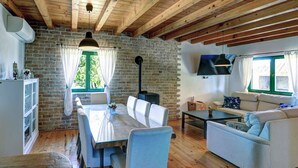 Une pièce rustique comprenant une table à manger, des chaises, un canapé, un téléviseur et une cheminée.