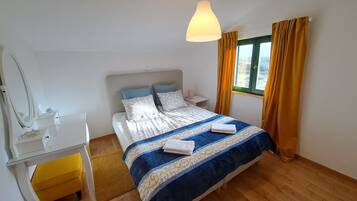 Une chambre à coucher bien rangée, avec un lit, une table de chevet et un miroir.