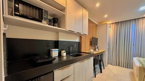 Una cucina moderna con microonde, macchina del caffè e lavello. È presente una zona pranzo con tavolo e sedie.