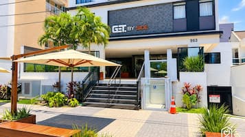 A modern building with a sign 'GET. BY SIDE' and a staircase leading to the entrance.