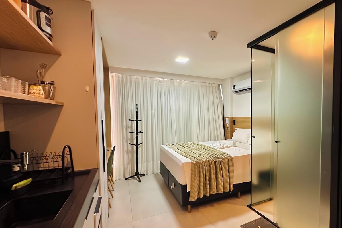 Ein Hotelzimmer mit Bett, Schreibtisch, Stuhl, Kleiderständer und Kleiderschrank.