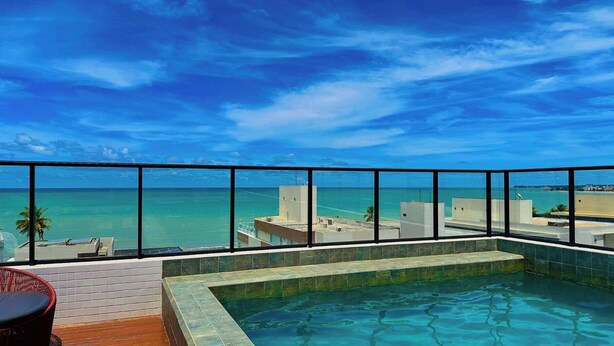 Una piscina sul tetto con vista sull'oceano e sulla città.