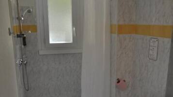 A bathroom with a shower, toilet, and sink.