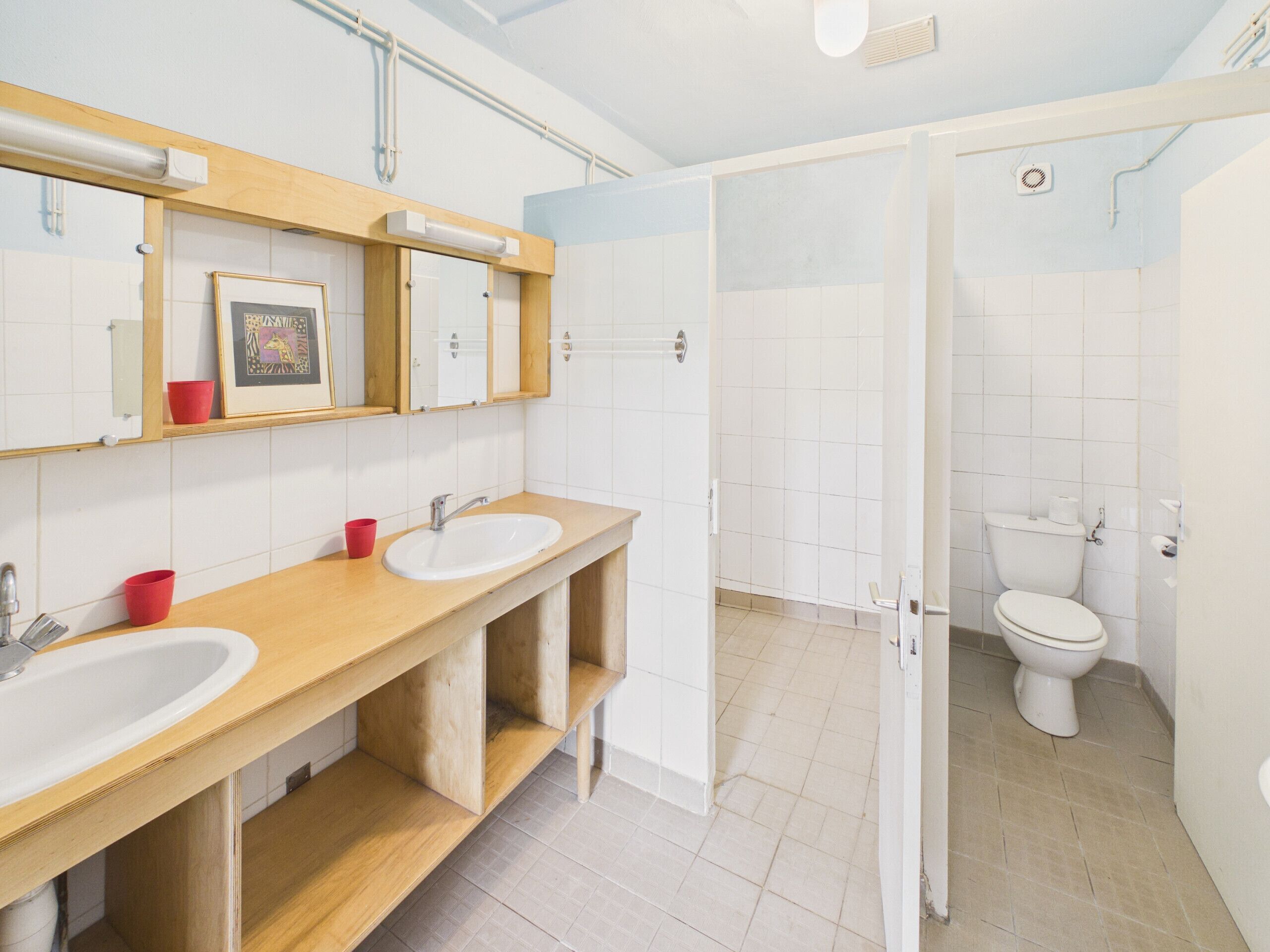 Une salle de bain avec deux lavabos, des toilettes et un espace douche.
