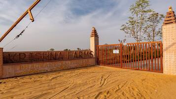 Uma entrada com portão e placa com as inscrições 'KRISHNA FARMS' e 'BHAGWANPURAPUSHKAR'.