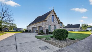Ein eingeschossiges Haus mit Natursteinfassade, einem Satteldach und einem Vorgarten mit einem kleinen Busch.
