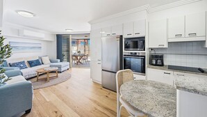 A modern kitchen with white cabinets, a built-in oven, and a refrigerator. - Riviera 102: 2  BR, 2  BA Apartment in Port Macquarie, Sleeps 4 (Port Macquarie)