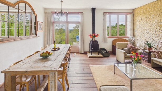 A dining area with a wooden table and chairs, a fireplace, and a sofa. - Family cottage for 6, share pool & garden (Fanlac)
