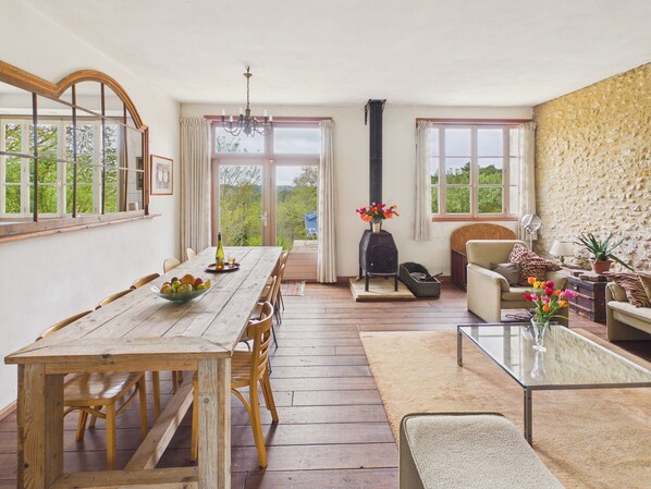 Un coin repas avec une table et des chaises en bois, une cheminée et un canapé.