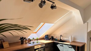 Una cucina moderna con lucernario, piano di lavoro in legno, forno integrato e mobili scuri.