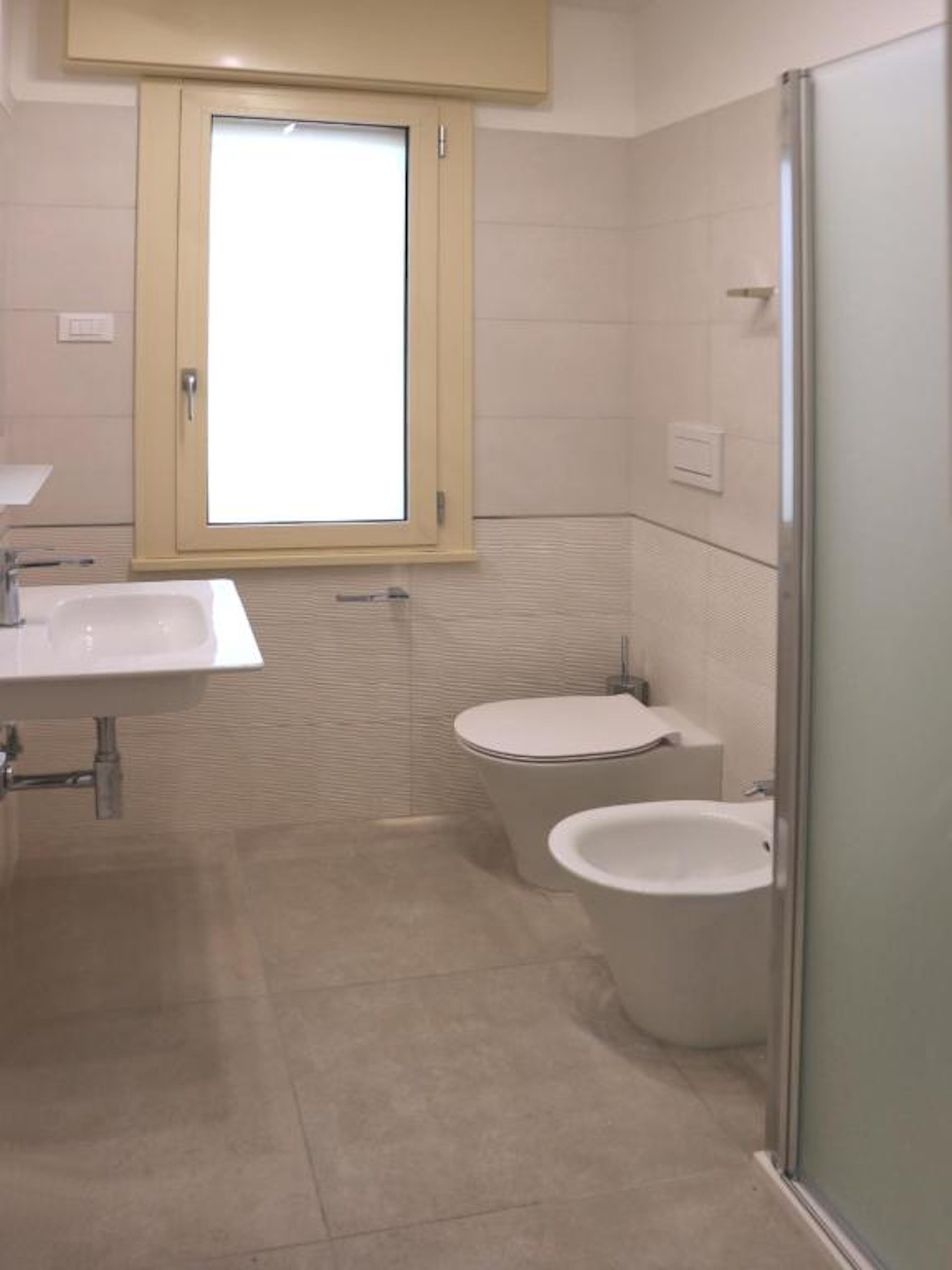 Un baño con inodoro, bidé y lavamanos.
