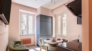 A modern kitchen with a dining table, chairs, and a built-in oven. - DEZA| Monti Incanto Boutique Apartment (Roma)