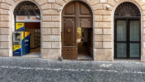A stone building with two arched doorways, an ATM on the left, and a closed door on the right. - DEZA| Monti Incanto Boutique Apartment (Roma)