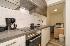 A modern kitchen with a coffee maker, oven, and microwave. - Spacious 35 m² studio apartment for 2 people in Crikvenica (Crikvenica)