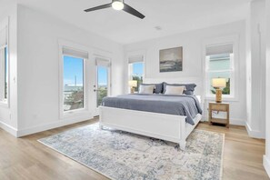 A bedroom with a bed, a ceiling fan, a window with blinds, and a view of the outdoors. - Ocean View 5BR - Steps To Beach w/Parking/Elevator (Carolina Beach)