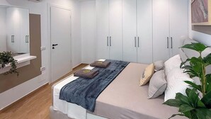 Een moderne slaapkamer met een bed, een witte kledingkast en een airconditioning.