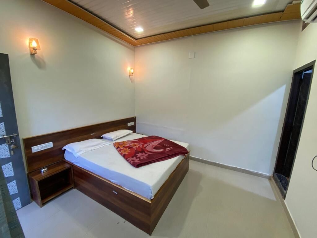 A bedroom with a wooden bed, bedside tables, and wall-mounted lights.