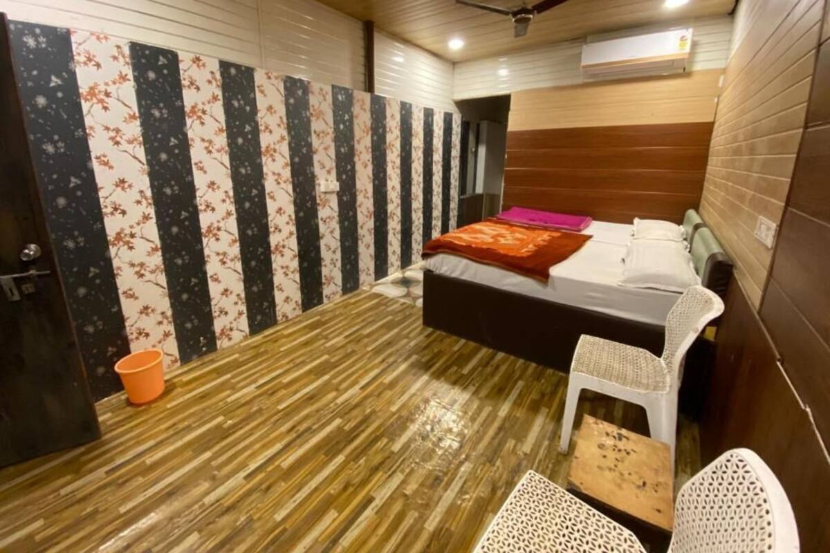 Um quarto com uma cama, um ventilador de teto, uma mesinha e uma cadeira.