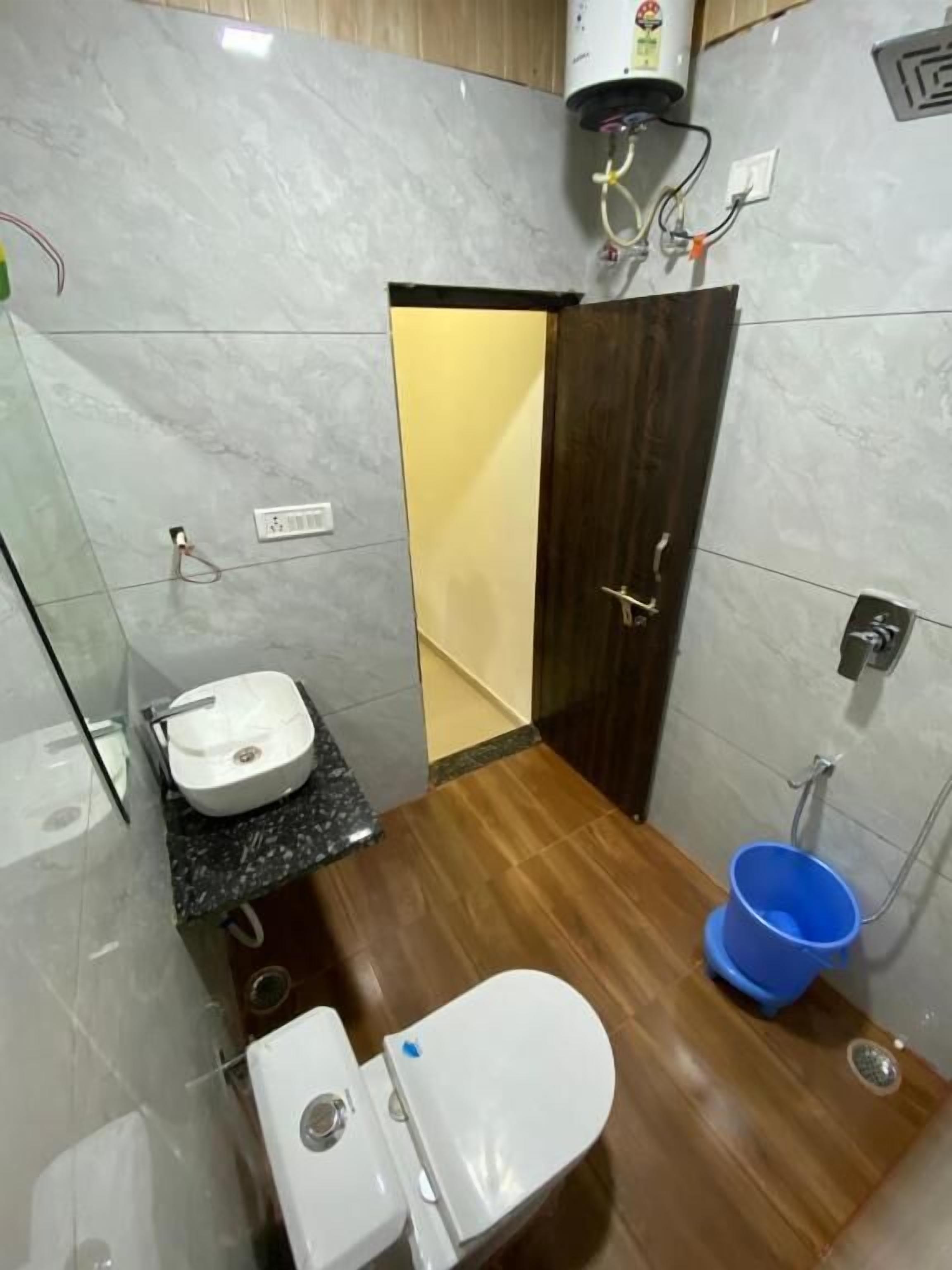Un baño pequeño con inodoro, lavamanos y zona de ducha.