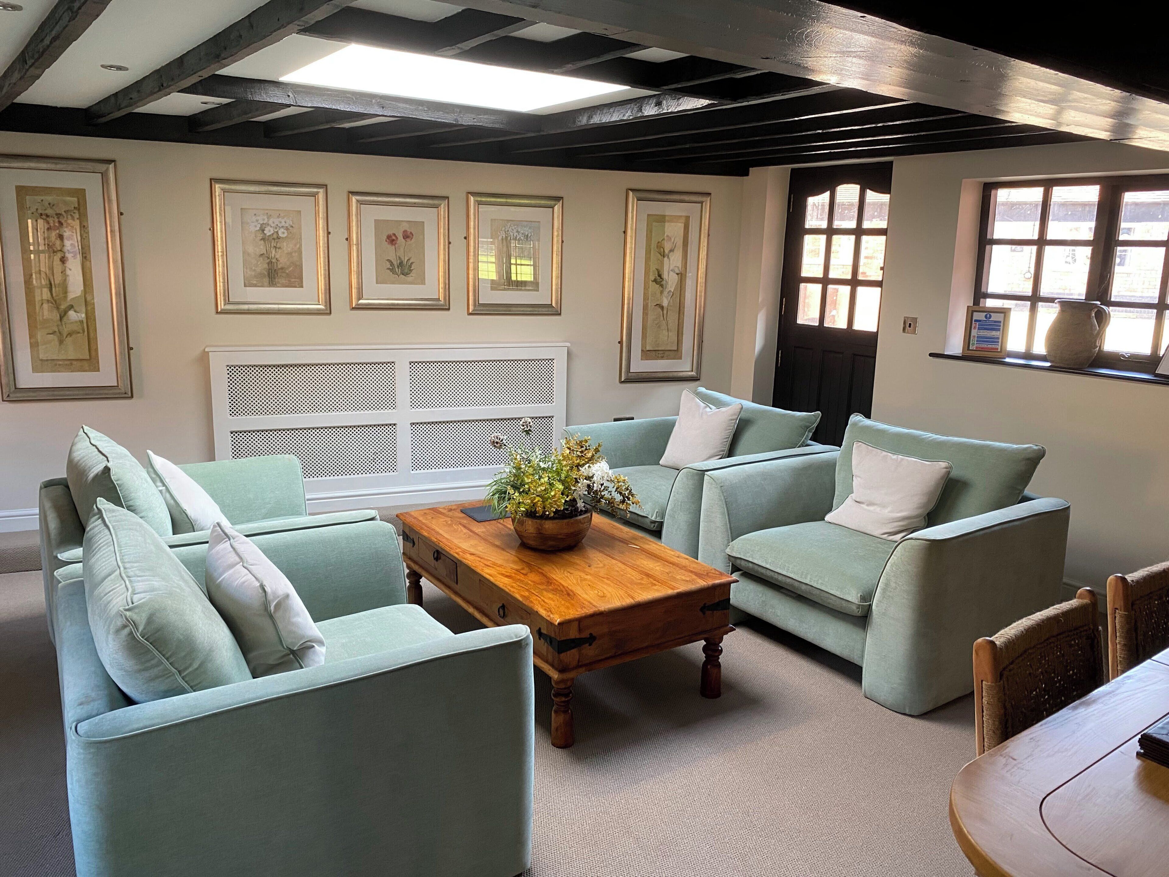 A room with a light blue sofa set, a wooden coffee table, and a white radiator.