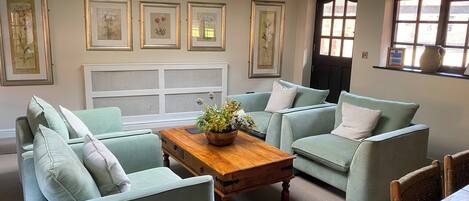 A room with a light blue sofa set, a wooden coffee table, and a white radiator.