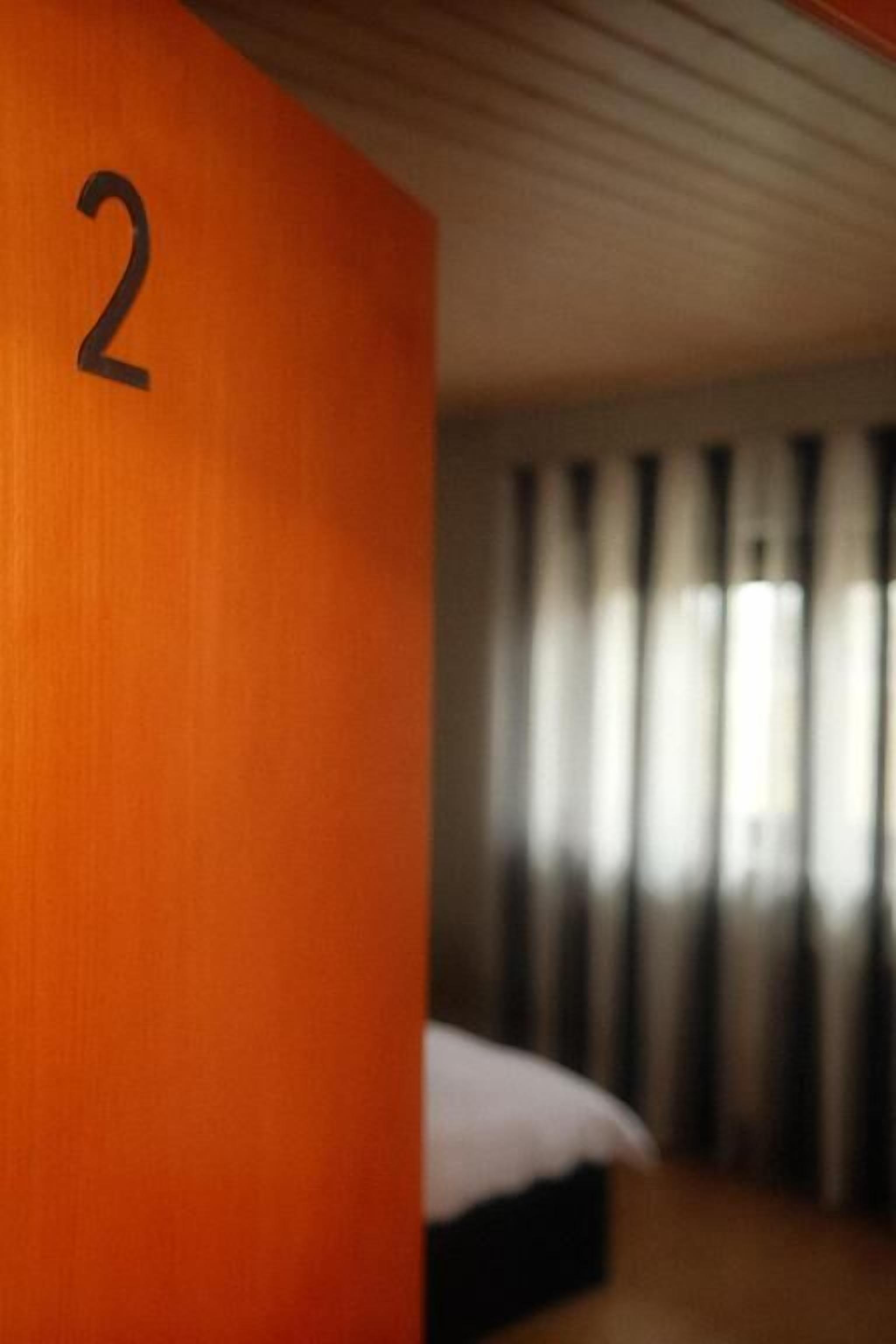 Habitación de hotel con una pared de madera que presenta el número 2 grande.