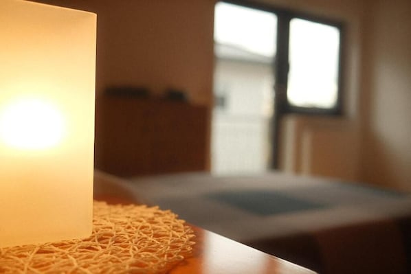 A room with a bed, a window, and a lamp.