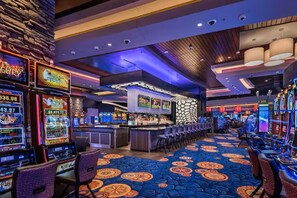A casino interior with slot machines, a bar area, and a patterned carpet. - Fountain Hills Gem >Pool, Balcony & Mountain View (Fountain Hills)