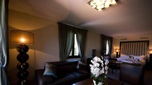 Ein Hotelzimmer mit Sofa, Couchtisch und einem Bett, auf dem ein Fahrrad steht.