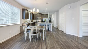 A modern kitchen with a dining area, wooden flooring, and a chandelier. - Sleeps 18 5BR Walden Home Near Lake Conroe & Margaritaville (Montgomery)