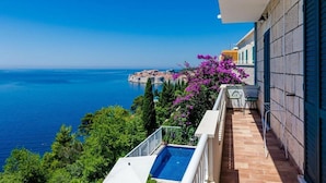Ein Balkon mit Pool, Blick auf das Meer und eine entfernte Insel.