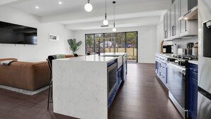 Una cucina moderna con isola centrale, elettrodomestici integrati e un'ampia finestra che offre vista sull'esterno.