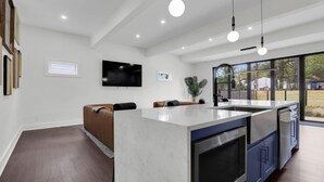 Una cucina moderna con una grande isola, elettrodomestici integrati e un'ampia finestra che offre una vista.