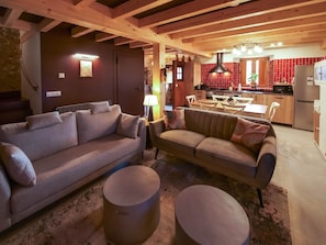 A cozy living room with a sofa, a coffee table, and a dining area with a table and chairs.