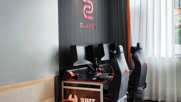 Una configuración de juego con múltiples monitores, un teclado y sillas ergonómicas.