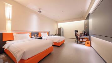 Habitación de hotel con dos camas, un escritorio, una silla, un televisor y un minibar.