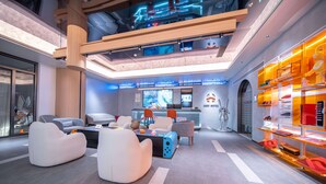 Un hall d’hôtel moderne, doté de mobilier contemporain, d’un comptoir d’accueil et d’un logo de marque bien visible.