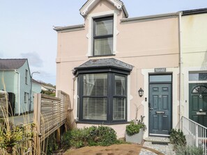A two-story building with a bay window, a dark door, and a small garden area. - Bryn Y Mor (Beaumaris)