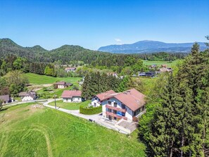 Ein Wohngebiet mit Häusern, einer Straße und einem Bergpanorama im Hintergrund.