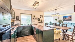 Une cuisine moderne dotée d’un îlot central, de planchers en bois et d’un coin repas avec un canapé et des chaises.